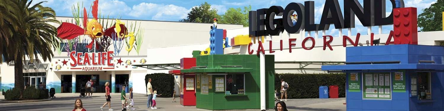 A sunny theme-park entrance featuring LEGO and Sea Life Aquarium signs at Legoland California.